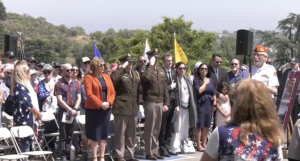 people salute the American flag at the memorial day event at Eternal Valley.